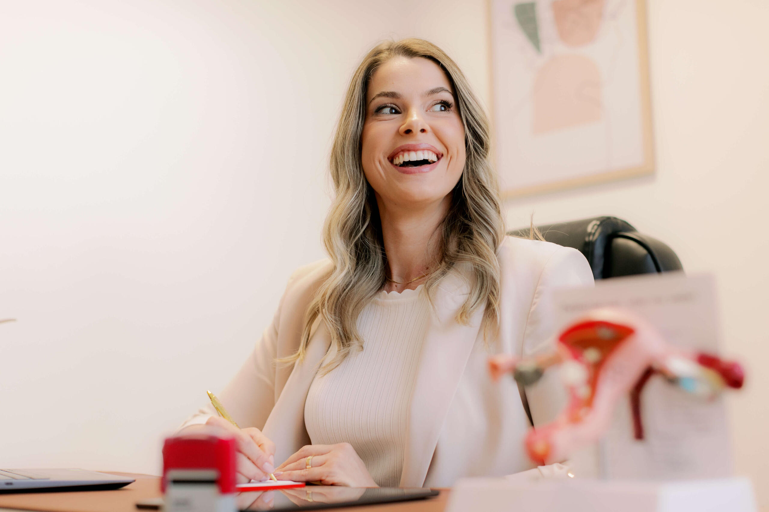 Dra. Larissa Gianotti escrevendo em consultório médico, especialista em saúde da mulher